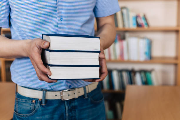 istock Male hands holding a stack of books. 1143532956