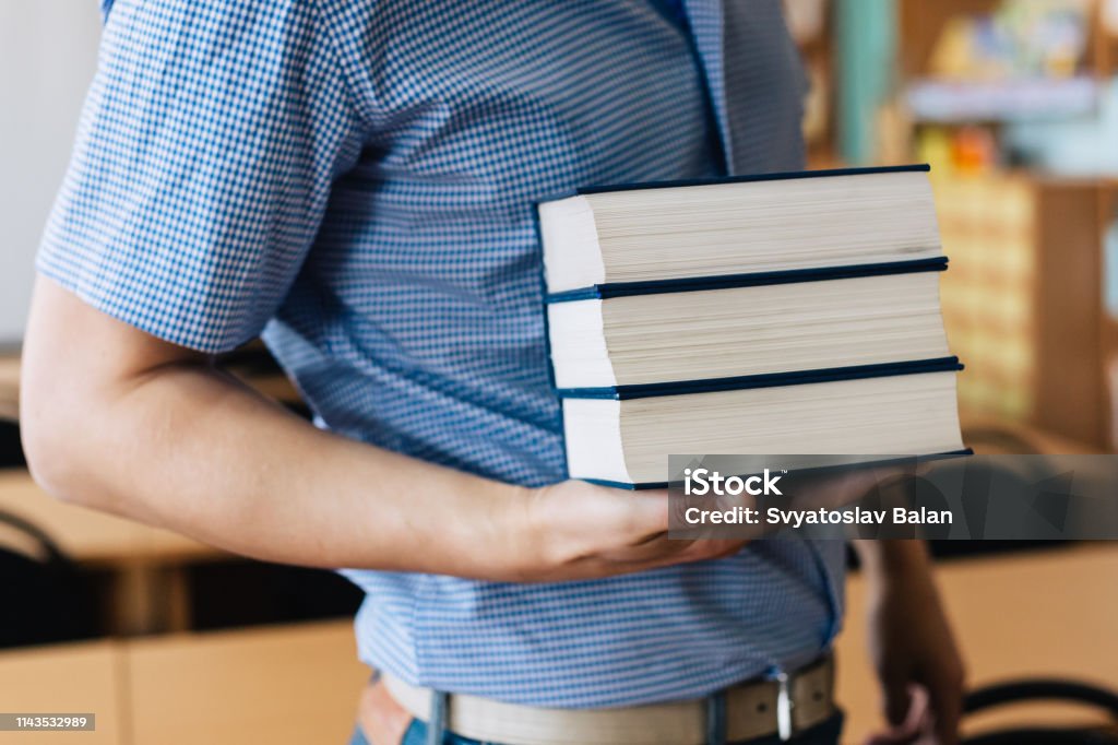 Stack of books lying on the palm Book Stock Photo