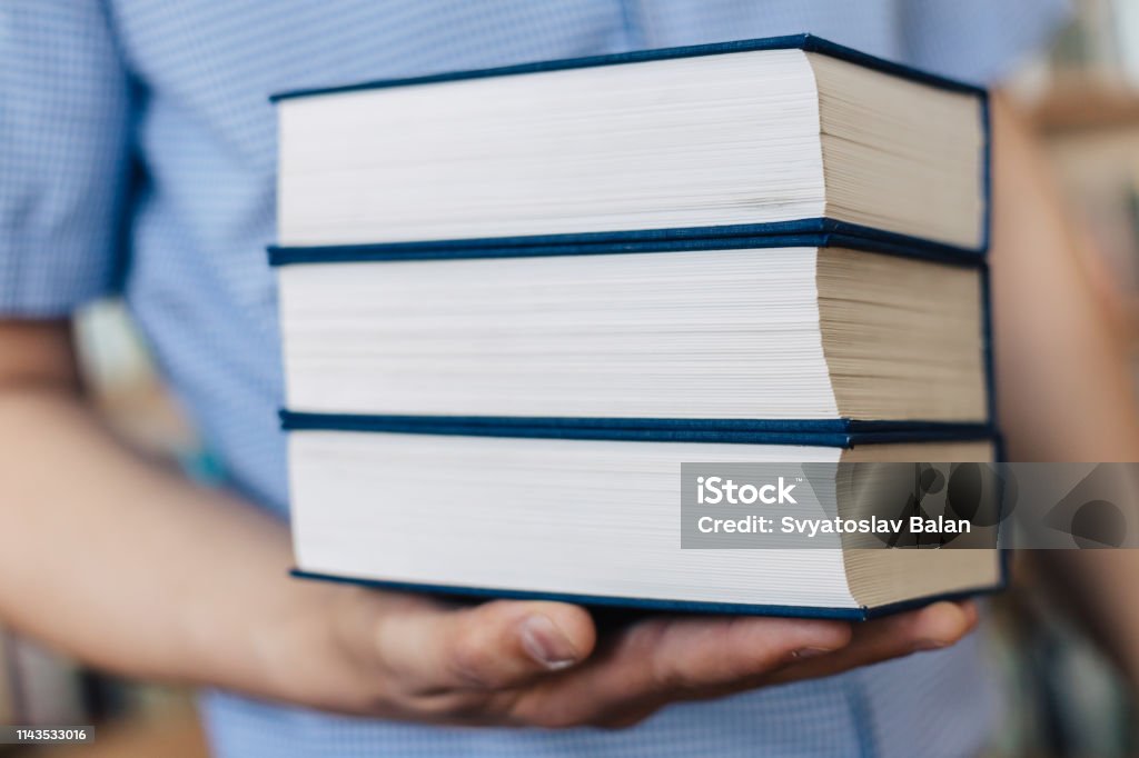 Stack of books lying on the palm Advice Stock Photo