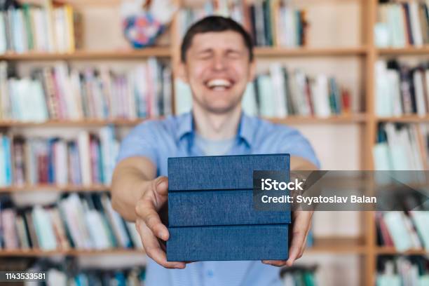 Male Hands Holding A Stack Of Books Man Holds Out A Stack Of Books Stock Photo - Download Image Now