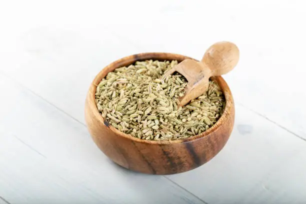 Dried Anise Seed or Aniseed in wooden bowl on white background.