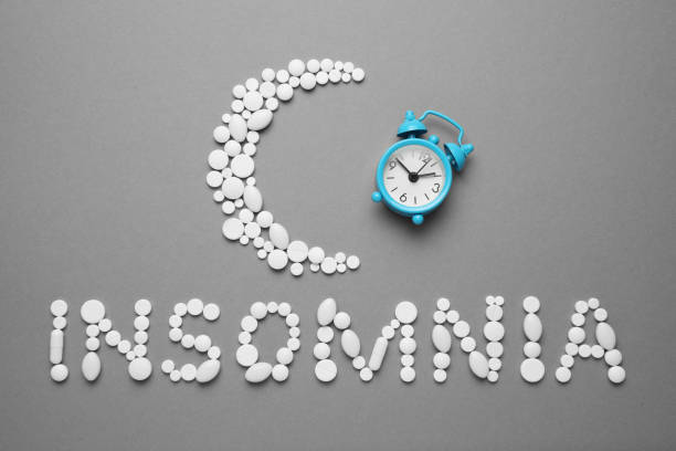 istock Sleeping pills and an alarm clock, insomnia concept. Medications for fatigue and sleep problems 1143534298