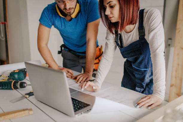 istock Happy couple using laptop while being on construction site in their apartment. 1143537947