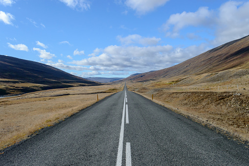 Road with cloudscape at autumn in North Iceland