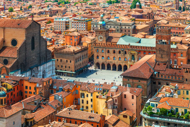 Italy Piazza Maggiore in Bologna old town Italy Piazza Maggiore in Bologna old town tower of town hall with big clock and blue sky on background, antique buildings terracotta galleries. bologna photos stock pictures, royalty-free photos & images