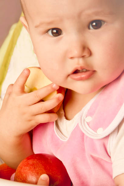 istock Cute little girl smiles while holding red apples. 1143539803