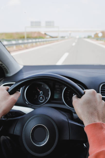 istock Young man driving a car, interior shot 1143542358