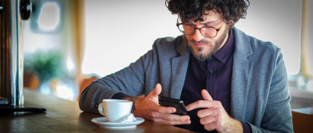 istock Man sitting in the coffee shop and using smart phone 1143542383