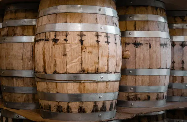 production of alcohol in oak barrels. Barrels placed in a row or stacked on top of one another