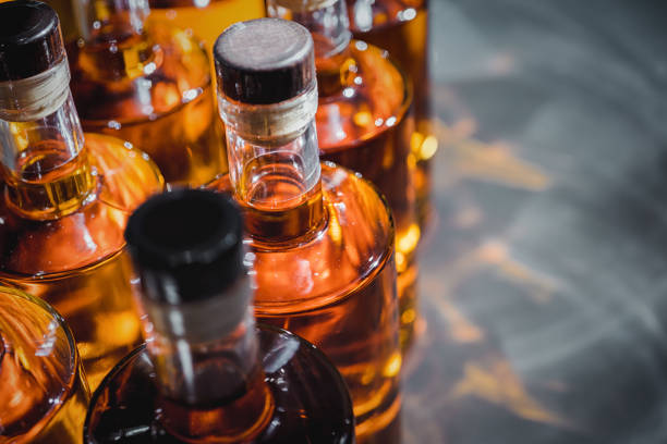 bottles of strong liquors in production - bottle imagens e fotografias de stock