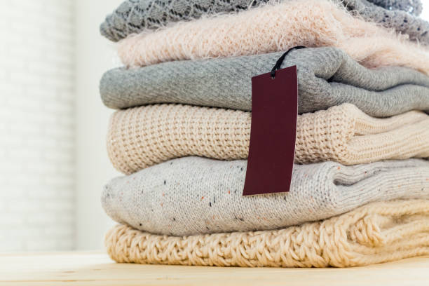 istock Stack of wool knitted warm sweater and white label for text 1143545040