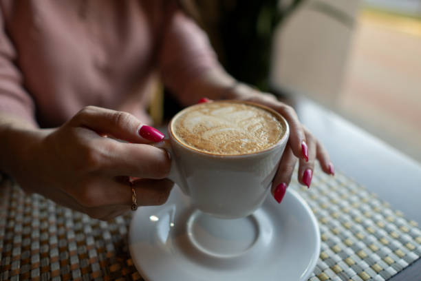 istock Female hand holding a white cup of coffee 1143546414