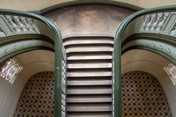 Green painted banister on wooden staircase in old house.