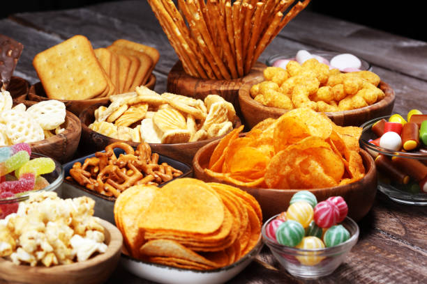 istock Salty snacks. Pretzels, chips, crackers in wooden bowls on table 1143548214