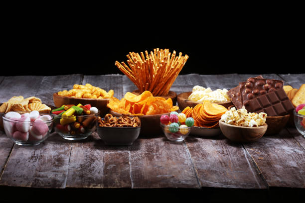 istock Salty snacks. Pretzels, chips, crackers in wooden bowls on table 1143548282