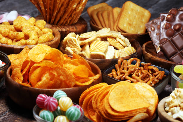 istock Salty snacks. Pretzels, chips, crackers in wooden bowls on table 1143549063