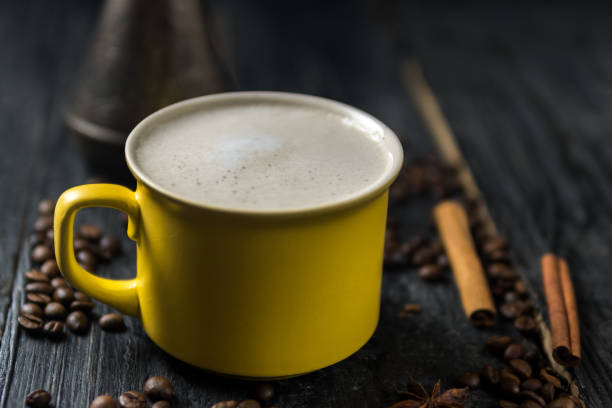 istock Cappuccino coffee mug with coffee beans on wooden table 1143551042