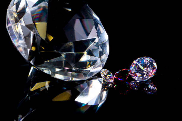 istock Huge diamond and several chic crystals on a deep black mirror surface, shimmer and sparkle 1143551679