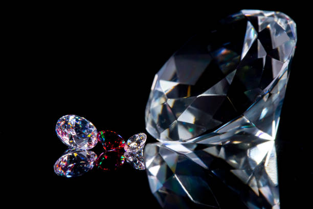 istock Huge diamond and several chic crystals on a deep black mirror surface, shimmer and sparkle 1143551704
