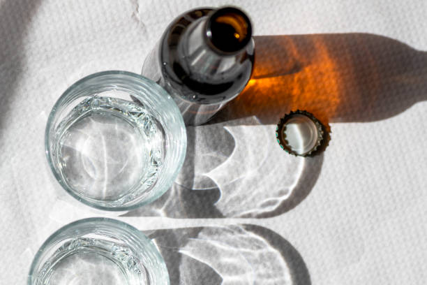 istock Two cristal glasses and one beer bottle on a white paper tablecloth. 1143553224