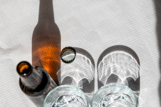Two cristal glasses and one beer bottle on a white paper tablecloth.