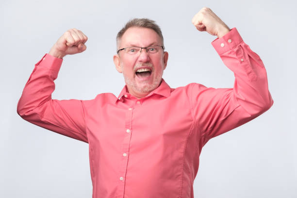 istock man in red shirt and glasses gesturing his win 1143553333
