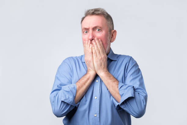 istock Senior man covers mouth and looks desperately 1143555525