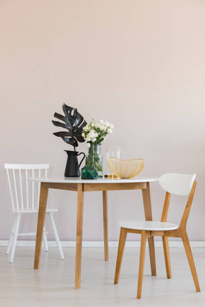 istock Stylish dining room with round table and elegant chairs, copy space on the empty wall 1143558486