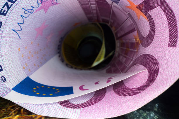 Inside the money tunnel. Abstract perspective view of euro back notes rolled in a tube. Saving and investing money Inside the money tunnel. Abstract perspective view of euro back notes rolled in a tube. Saving and investing money european union currency france number 50 coin stock pictures, royalty-free photos & images