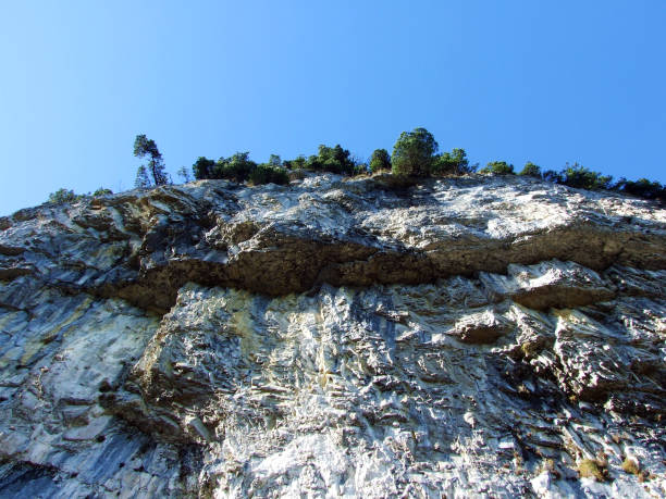 penhasco de äscher ou äscher-felsen (aescher-felsen ou ascher-felsen) na escala de montanha de alpstein e na região de appenzellerland - ascher - fotografias e filmes do acervo