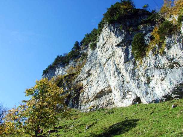 äscher cliff o äscher-felsen (aescher-felsen o ascher-felsen) en la cordillera de alpstein y en la región de appenzellerland - ascher fotografías e imágenes de stock