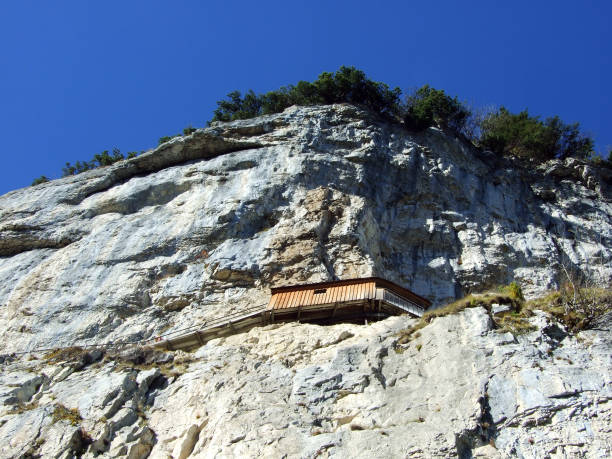 äscher cliff o äscher-felsen (aescher-felsen o ascher-felsen) en la cordillera de alpstein y en la región de appenzellerland - ascher fotografías e imágenes de stock