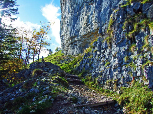 äscher cliff or äscher-felsen (aescher-felsen or ascher-felsen) in the alpstein mountain range and in the appenzellerland region - ascher imagens e fotografias de stock