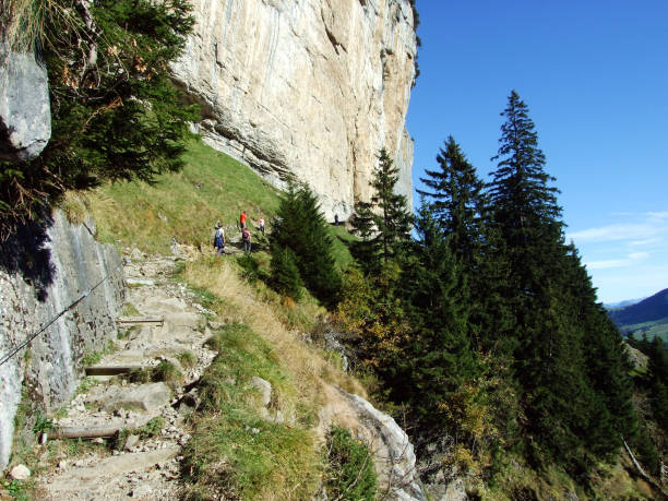 penhasco de äscher ou äscher-felsen (aescher-felsen ou ascher-felsen) na escala de montanha de alpstein e na região de appenzellerland - ascher - fotografias e filmes do acervo