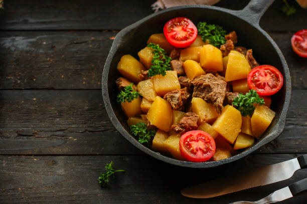 istock stewed potatoes with meat, goulash. stewed main course. food background. top 1143565287