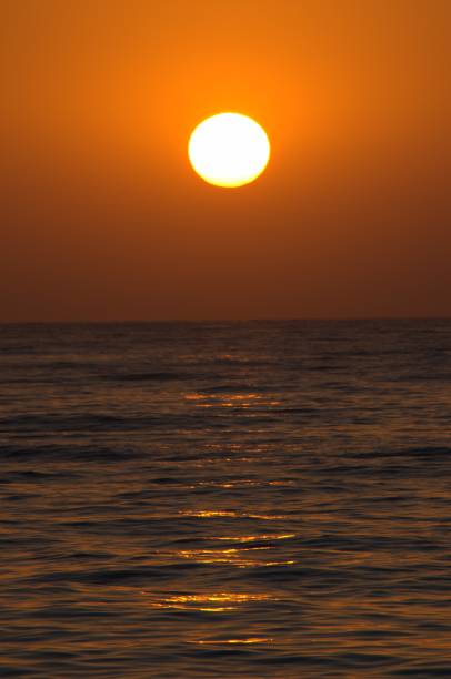 istock Sunset with large yellow sun under the sea surface 1143569600