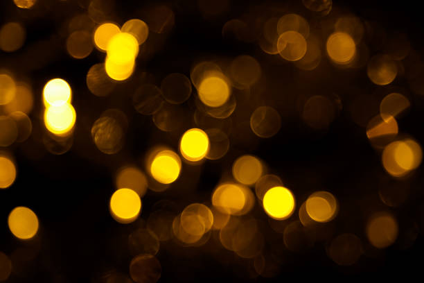 istock Abstract gold bokeh on black background. Defocused yellow lights, abstract texture 1143577894