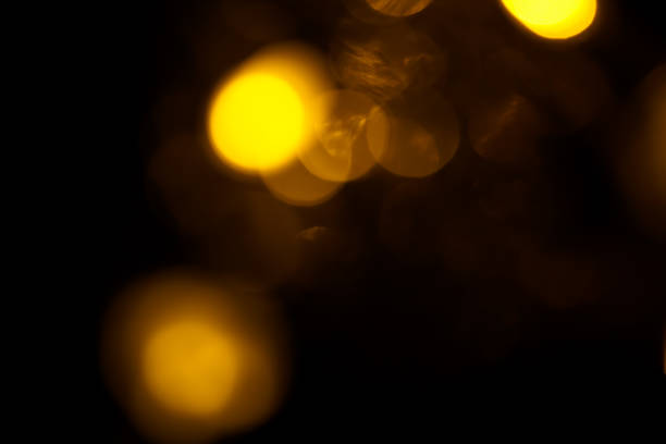 istock Abstract gold bokeh on black background. Defocused yellow lights, abstract texture 1143578005