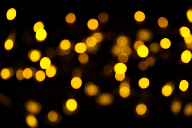 istock Abstract gold bokeh on black background. Defocused yellow lights, abstract texture 1143578090