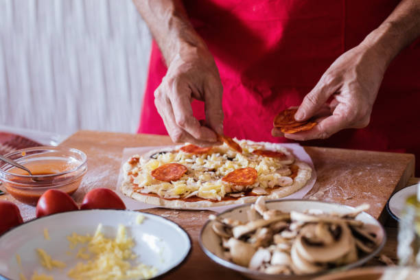 istock Making pizza, pepperoni sausage topping, close-up 1143578656