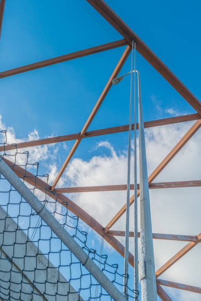 istock Looking up at the top architectural structure of an interstate bridge with blue skies and puffy white cloud in the background - diamond shapes in bridge structure 1143581712