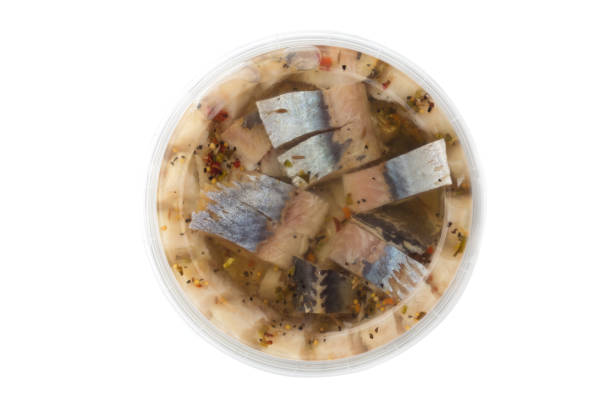 istock Marinated fish in a plastic container. Pieces of pickled herring in the package from the store on a white background. 1143586587