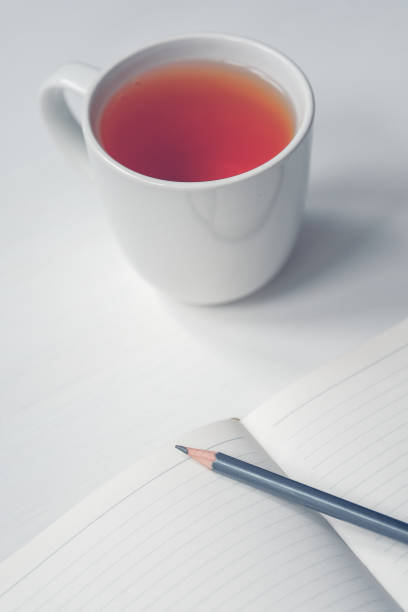 istock Cup of tea with notebook and pencil on wooden table. 1143587002