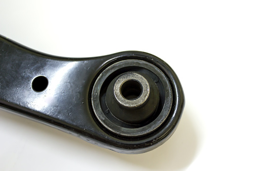 Bushing on front lower control arm for Japanese car on white background, isolated.