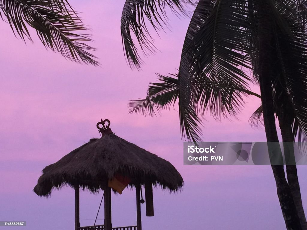 Beach hut against pink sky Beach hut in Bali at Sunset Beach Hut Stock Photo