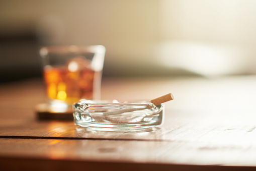 Alcohol on coffee table with cigarette and ashtray