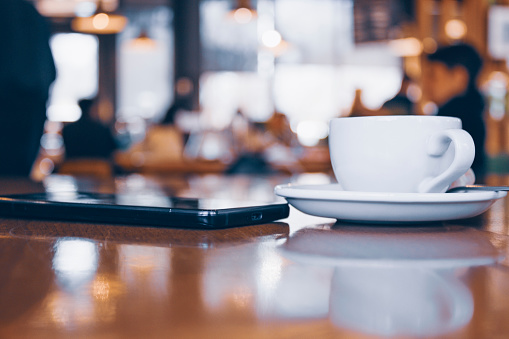 Coffee mug and mobile phone on the table