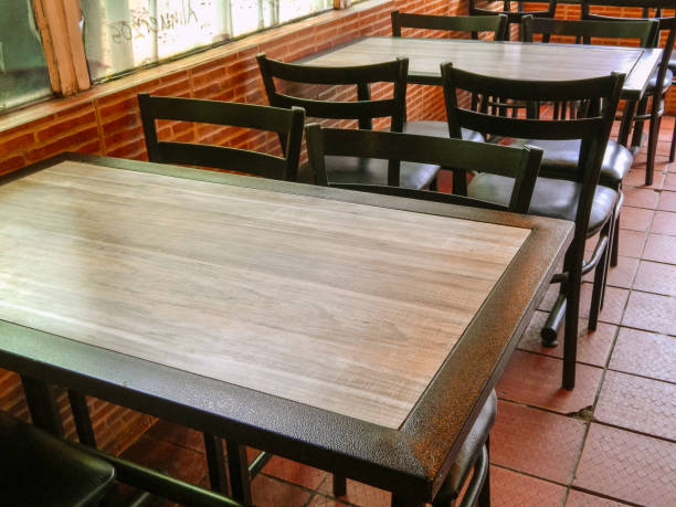 istock Chairs and tables in a restaurant next to a bricks wall 1143595331