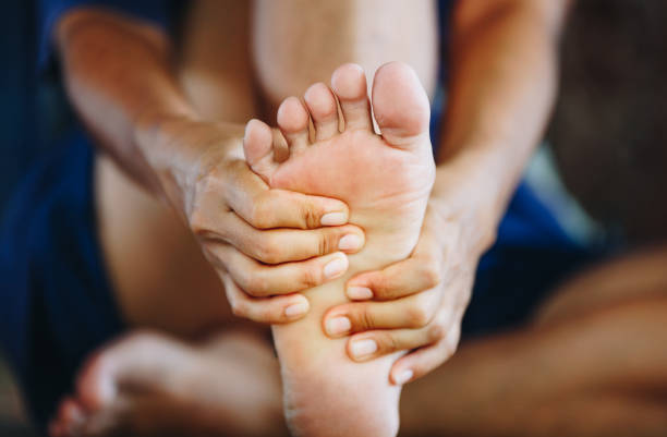 young woman massaging her painful foot , health care concept stock photo