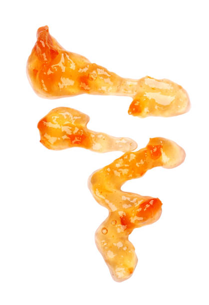 istock Orange thick jam drizzle, isolated on white background. Mandarin marmalade, sauce, topping drops. Top view. 1143601341